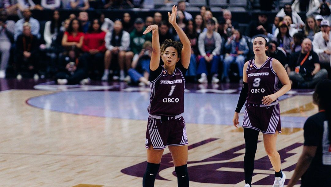Kiki Rice shoots a three while Marina Mabrey watches.